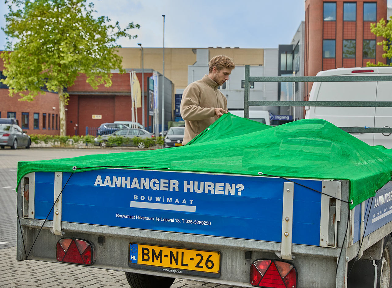 vakman plaatst zeil over aanhanger bij Bouwmaat vestiging
 - service media