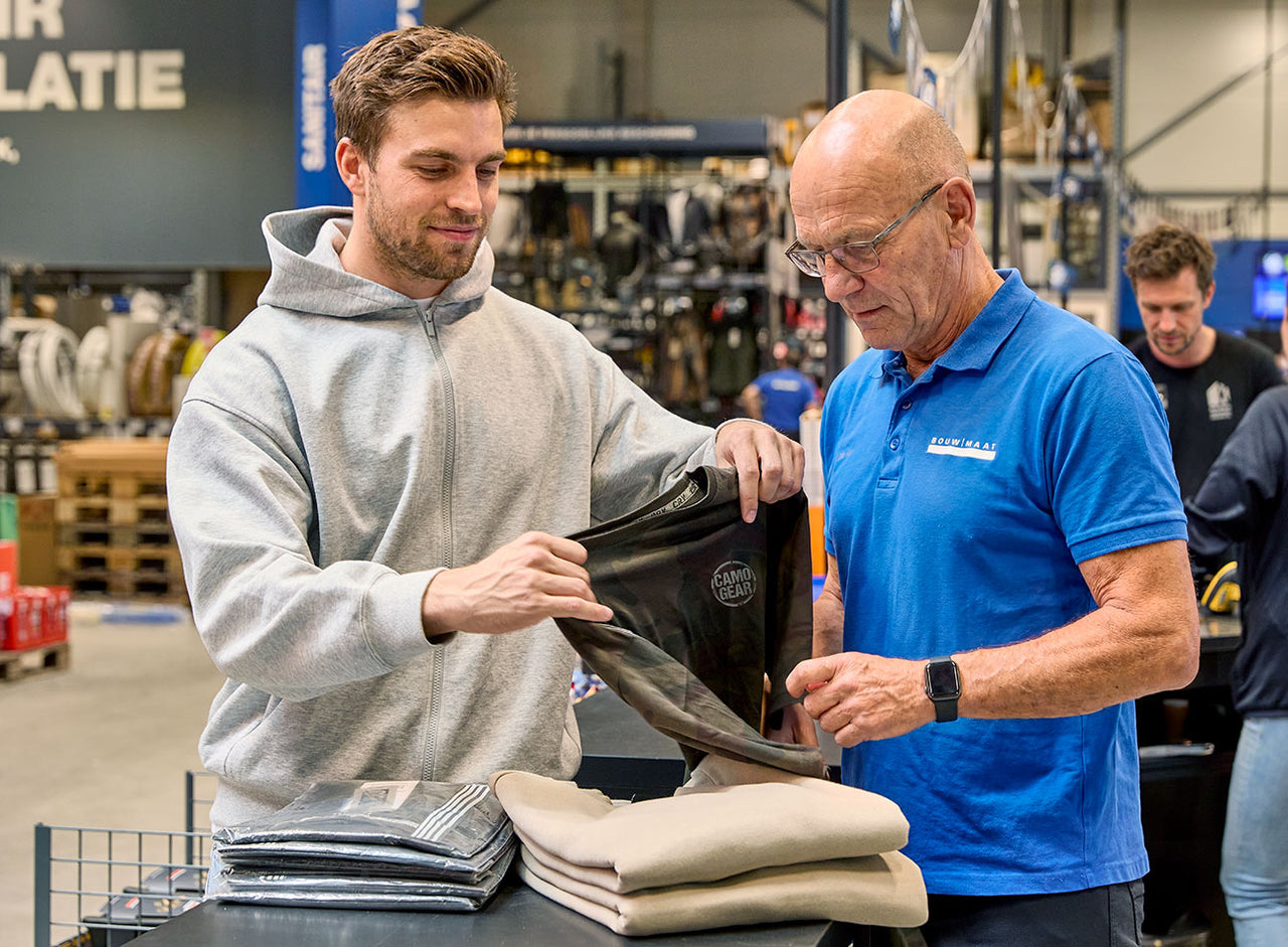 vakman en medewerker controleren bedrukte werkkleding
 - service media