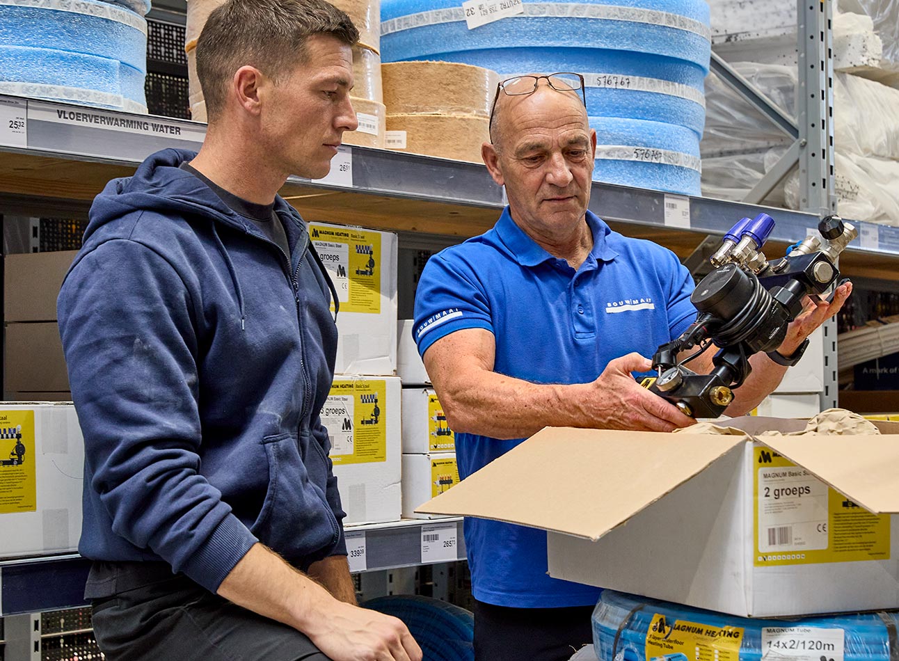 medewerker toont vloerverwarmingsonderdeel aan vakman in magazijn
 - article 3