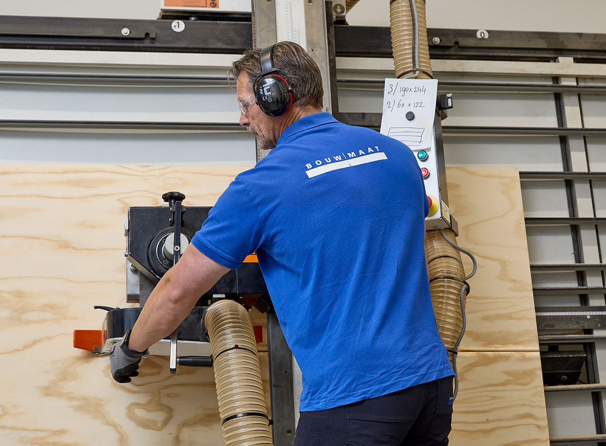 medewerker zaagt plaatmateriaal op maat in werkplaats
