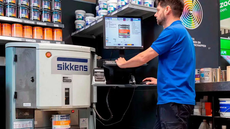 Medewerker van Bouwmaat aan het werk bij de verfmengbalie