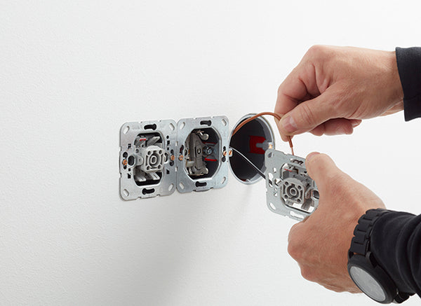 Elektricien sluit een inbouwschakelaar aan tijdens het aanleggen van elektra in de badkamer - card 1