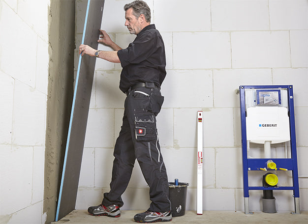 Vakman plaatst een Wedi bouwplaat tegen de wand voor het opbouwen van een inloopdouche - media 1