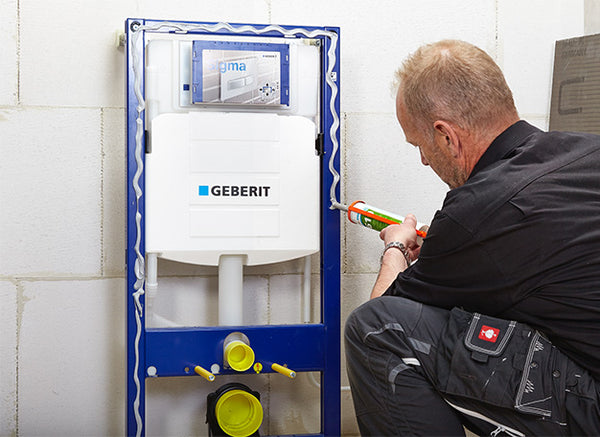 Vakman verlijmt Wedi bouwplaten rondom een inbouwreservoir voor een toiletombouw - card 3